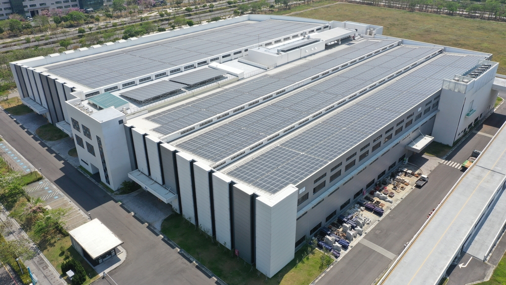 A large commercial facility with solar panels on its large roof.