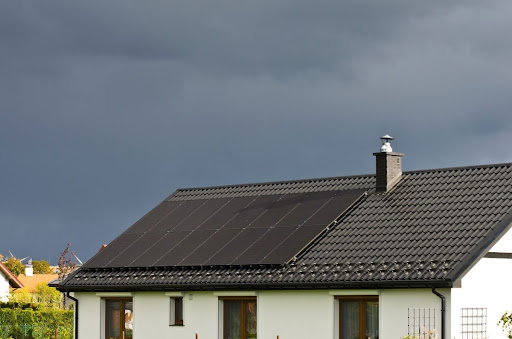 Solar panels on the roof of a house. The sky is cloudy.